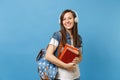 Portrait of young smiling lovely woman student in denim clothes with backpack headphones listening music, holding school Royalty Free Stock Photo