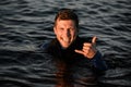 Portrait of young smiling man in water showing surfer gesture Royalty Free Stock Photo