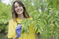 Portrait of young smiling nurse woman taking care of plants in nature Royalty Free Stock Photo