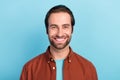 Portrait of young smiling positive guy in brown shirt laughing with perfect white veneer teeth isolated on blue color