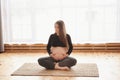 Pregnant woman practicing yoga at home