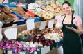 young smiling saleswoman in store with onions in hands