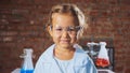 Portrait of a young smiling scientist child girl in a chemistry lab.