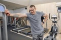 Portrait of young smiling strong muscular man in the gym