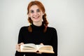 Portrait of young smiling student girl with an open book in her hands. Reading and education concept Royalty Free Stock Photo