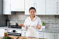Portrait of a young smiling woman chef standing in the middle of the kitchen. Cooking vegan pizza Royalty Free Stock Photo