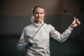 A portrait of a young smiling woman fencer bending a singlestick