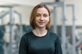 Portrait of young smiling woman in the gym, female fitness instructor looking at the camera Royalty Free Stock Photo