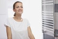 Portrait of young smiling woman looking at herself in bathroom mirror Royalty Free Stock Photo