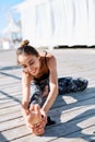 Photo of young smiling woman make yoga exercises on a wooden pier. Royalty Free Stock Photo