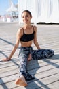 Portrait of young smiling woman make yoga exercises on a wooden pier. Royalty Free Stock Photo