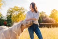 Portrait of young smiling woman petting white pony Royalty Free Stock Photo
