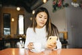 Young woman using a phone in a coffee shop Royalty Free Stock Photo