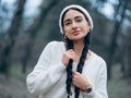 Portrait of young smiling woman in white hat with braided hair and piercing on her face Royalty Free Stock Photo