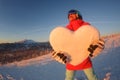 Portrait of young snowboarder girl with snow heart in hands Royalty Free Stock Photo