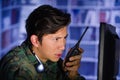 Portrait of young soldier wearing a military uniform, military drone operator watching at his computer and using a radio