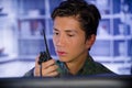 Portrait of young soldier wearing a military uniform, military drone operator watching at his computer and using a radio