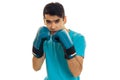 Portrait of young sportsman with dark hair practicing boxing in blue gloves and uniform isolated on white background Royalty Free Stock Photo