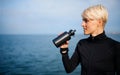 Portrait of young sportswoman standing outdoors on beach, drinking. Royalty Free Stock Photo