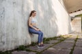 Portrait of young sporty woman in sportswear excercising in front of concrete wall in the city. Royalty Free Stock Photo