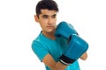 Portrait of young strong man in blue shirt practicing boxing in gloves isolated on white background Royalty Free Stock Photo