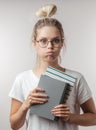 Portrait of young student girl with books isolated over grey wall background Royalty Free Stock Photo