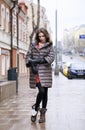 Portrait of a Young stylish brunette girl in a gray down jacket