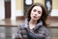 Portrait of a Young stylish brunette girl in a gray down jacket