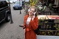 portrait of a young stylish woman walking around the city in headphones with a mobile phone with a smile on her face Royalty Free Stock Photo