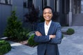 Portrait of young successful african american business woman happy and smiling looking at camera with arms crossed, outside office Royalty Free Stock Photo