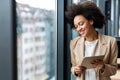 Portrait of young successful black woman working with tablet in office Royalty Free Stock Photo