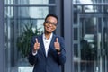 Portrait of young successful business woman, african american woman smiling happy looking at camera, wearing glasses, near modern Royalty Free Stock Photo