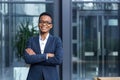 Portrait of young successful business woman, african american woman smiling happy looking at camera, wearing glasses, near modern Royalty Free Stock Photo