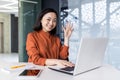 Portrait of young successful business woman in modern office using laptop, Asian woman with smiling and looking at Royalty Free Stock Photo