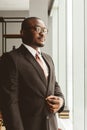 Portrait of a young successful businessman in a suit in the office. Close-up standing by the window Royalty Free Stock Photo