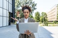 Portrait of young successful businesswoman office worker using laptop computer outside office building in formal wear. Royalty Free Stock Photo