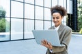 Portrait of young successful businesswoman office worker using laptop computer outside office building in formal wear. Royalty Free Stock Photo