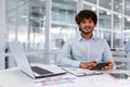 Portrait of young successful financier accountant at work inside office building at workplace, hispanic man smiling and Royalty Free Stock Photo