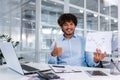 Portrait of young successful financier paperwork inside office, man smiling and looking at camera shows graph with Royalty Free Stock Photo