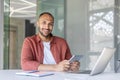 Portrait of a young successful man office worker programmer developer, looking at the camera smiling, with a tablet