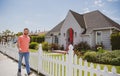 Portrait of young successful real-estate agent walking outdoor at dwelling for sale. Selling houses job. Real estate