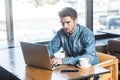 Portrait of young successful serious bearded businessman working on computer sitting in office Royalty Free Stock Photo