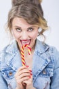 Portrait of Young Surprised Caucasian Blond Girl Eating Big Red-Yellow Candy Cane Royalty Free Stock Photo