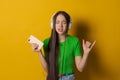 Portrait young teen girl posing isolated over yellow background wall listening Royalty Free Stock Photo