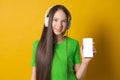 Portrait young teen girl posing isolated over yellow background wall listening Royalty Free Stock Photo