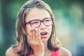 Portrait of young teen girl with toothache. Girl with dental braces and glasses Royalty Free Stock Photo