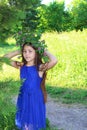 Portrait of a young teen girl in wreath of wild flowers and background of nature