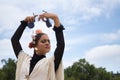 Portrait of young teenage girl in black dance dress, white shawl and pink carnations in her hair, dancing flamenco with castanets Royalty Free Stock Photo