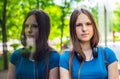 Portrait of young teenager brunette girl with long hair. an urban environment of a street warehouse, woman and reflection in the g Royalty Free Stock Photo