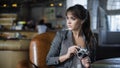 Portrait of young teenager photographer with long hair in black t-shirt in cafe. Beautiful girl holding old analog film camera in Royalty Free Stock Photo